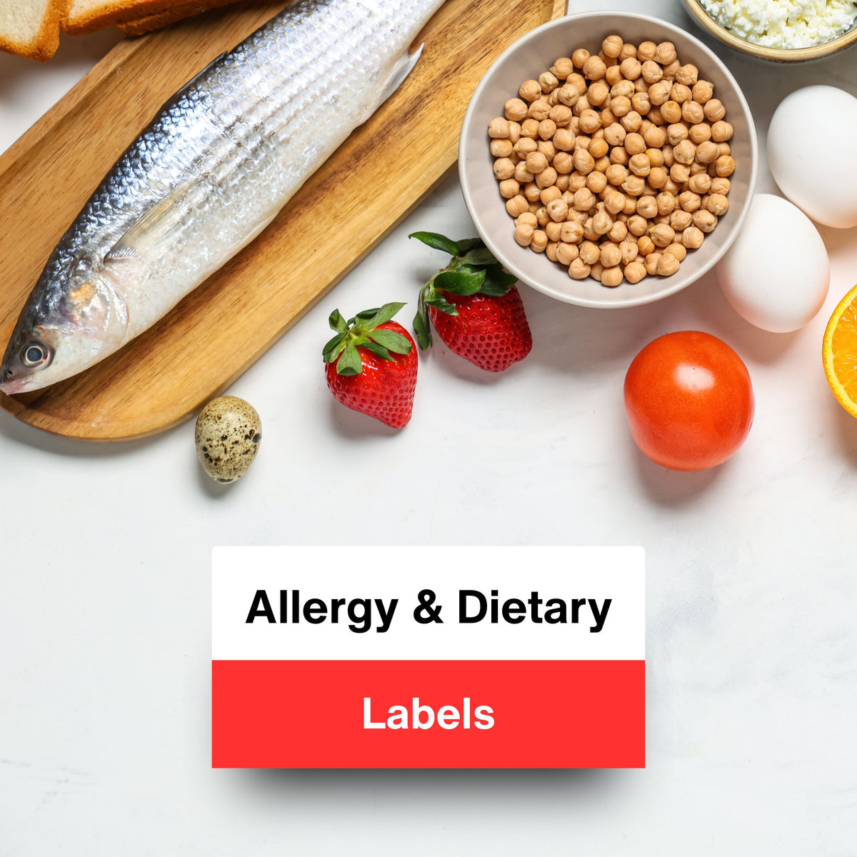 A styled flat-lay of various food items including a whole fish on a wooden board, a bowl of chickpeas, eggs, strawberries, a tomato, and an orange slice on a white marble surface. A white and red button graphic in the lower center reads 'Allergy & Dietary Labels'.